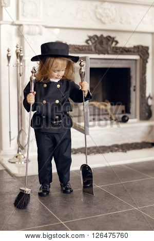 Girl as a chimney sweep against fireplace. Lucky New Year's Eve and New Year.