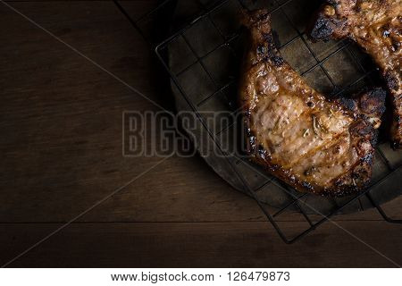 Grilled pork chops on wood background.(dark tone)