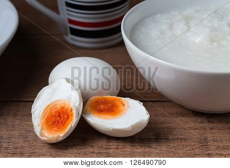 Salted egg and gruel chinese food on wooden background.