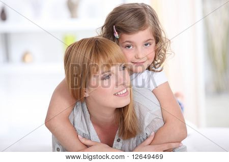 Portret van een klein meisje legde op de achterkant van een vrouw