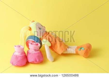 Babby Booties And Dolls On Yellow Background