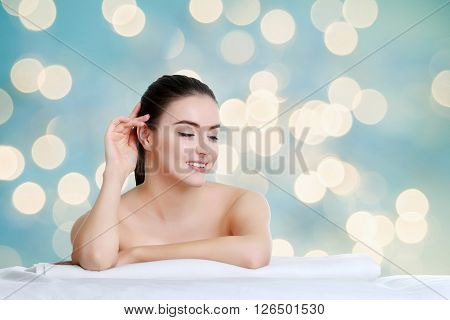 Young spa woman touching her face after beauty treatment