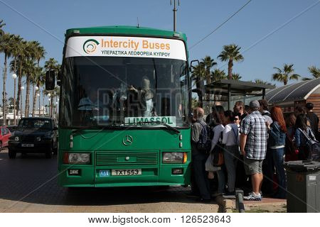 LARNACA, CYPRUS - MARCH 13, 2016: Lot of people in front of the intercity bus want to reach Limasol in the last day of the traditional carnival. The festival is a 10 day colorful annual event