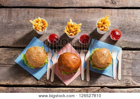 Burgers with fries and cutlery. Table with cutlery and burgers. Food that tastes good. Daily calorie norm.