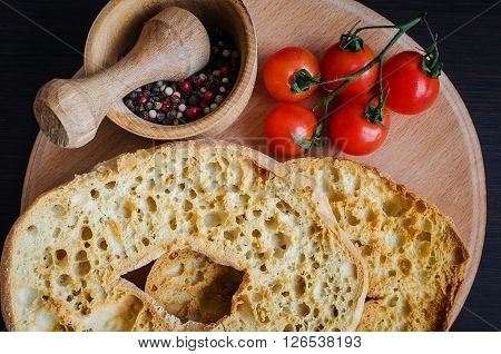 Italian dried bread Friselle on wooden board with tomatoes cherry and pepper. Italian food. Healthy vegetarian food.