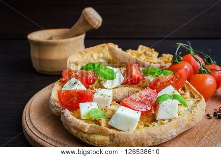Italian appetizer Friselle. Italian dried bread Friselle on wooden board with tomatoes cherry, basil and pepper. Italian food. Healthy vegetarian food. Antipasti concept. Selective focus.