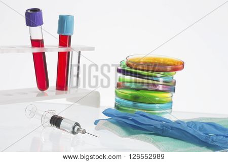 Biochemistry Research of blood tests. Cell culture for the biomedical diagnostic. Gloves,  petri dish for blood analysis,  Plastic labware for scientific research and personal protection equipment.