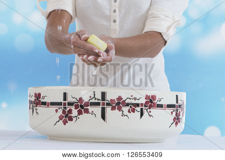 hands washing in an old ceramic bowl