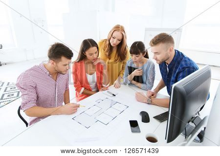 business, startup, architecture and people concept - creative architect team or students with blueprint working at office