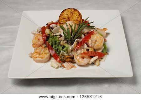 Salad of sea fruits on the square plate