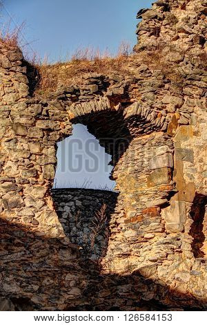 Strong walls of the castle ruins with window arch