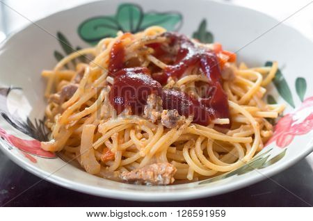 Fried spaghetti and pork with tomato sauce in plate