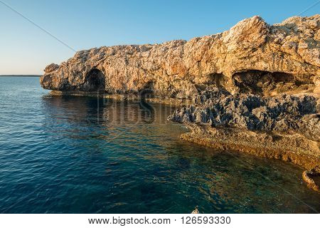 Wonderful sea landscape. Rocky shore calm sunny morning. Quiet clear sea.