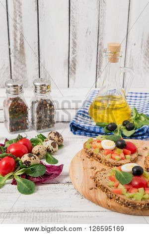 bruschetta with tomato olives and greenery on wooden table
