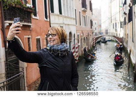 Traveling around the world. European cities. Beautiful modern woman making selfie. Local sights in the background.