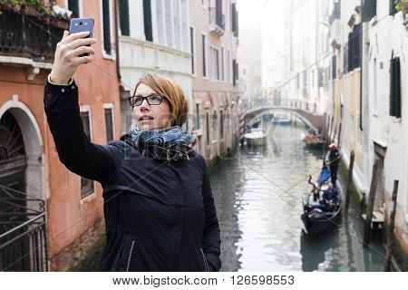Traveling around the world. European cities. Beautiful modern woman making selfie. Local sights in the background.