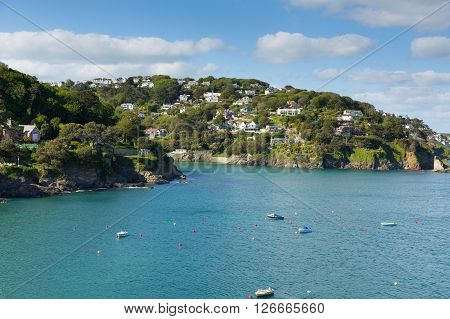 Salcome estuary Devon UK with boats and blue sky and houses on the hillside