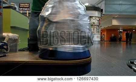 Borispil, Ukraine - March 25, 2016: Wrapping luggage baggage bag at the airport terminal for security reason and safety protection from damage.