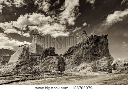 Ruins and Basgo Monastery surrounded with stones and rocks sky with clouds in the background Himalayan Mountain range Leh Ladakh Jammu and Kashmir India - tinted stock image of Indian monasteries