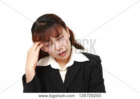 Asian businesswoman suffers from headache on white background