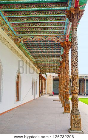 KOKAND UZBEKISTAN - MAY 6 2015: The scenic carved pillars and colorful canopy in the courtyard of the Jami Mosque covered with colorful floral patterns on May 6 in Kokand.