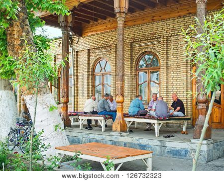 KOKAND UZBEKISTAN - MAY 6 2015: The locals enjoy the shady terrace of the teahouse on May 6 in Kokand.