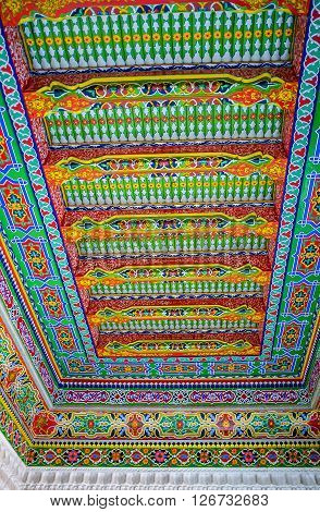 KOKAND UZBEKISTAN - MAY 6 2015: The ceiling in the Khudayar Khan Palace decorated with the wooden carvings and colorful arabesques on May 6 in Kokand.