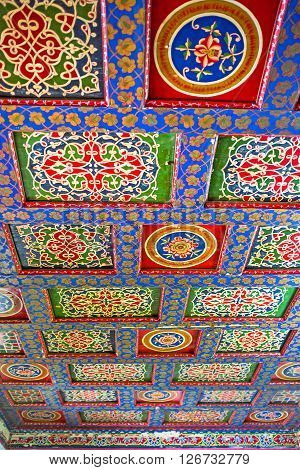KOKAND UZBEKISTAN - MAY 6 2015: The carved wooden ceiling in Khudayar Khan Palace consists of many colorful screens and frames between them decorated with beautiful islamic patterns on May 6 in Kokand.