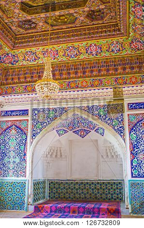 KOKAND UZBEKISTAN - MAY 6 2015: The Great Throne Room in Khudayar Khan Palace with the carved throne niche surrounded by islamic floral patterns and glazed tiles on May 6 in Kokand.