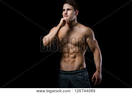 Man showing his six pack abs isolated on black background