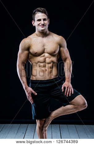Close up of sports muscular man on black background