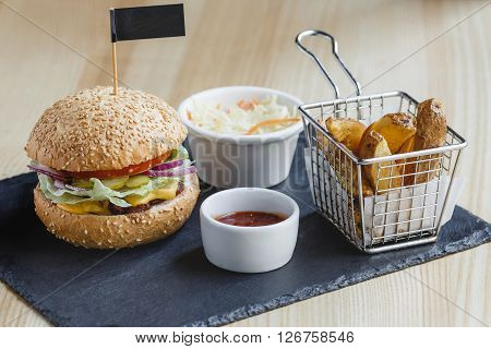 Burger with fried potato and sauce on the black plate
** Note: Visible grain at 100%, best at smaller sizes