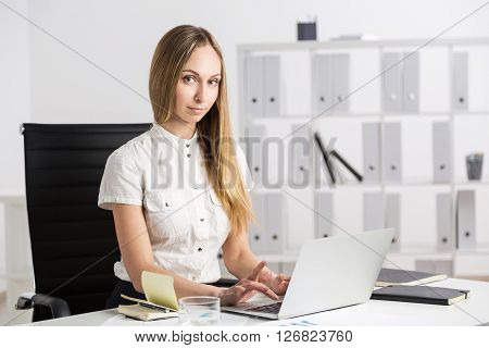 Female using laptop at office desk, close up