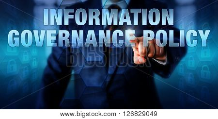 IT manager is pushing INFORMATION GOVERNANCE POLICY on a touch screen interface. Business strategy metaphor and information technology concept for IG practices aimed at improving compliance.