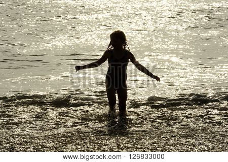Children playing in sunlit sea in summer