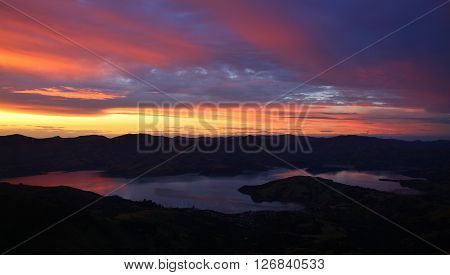 Sunset over Akaroa. Colorful evening sky over the Banks Peninsula, New Zealand.