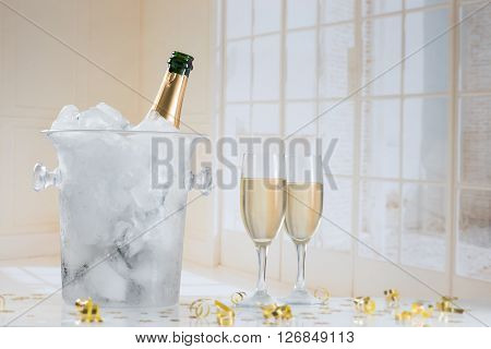 Glasses of champagne and bottle with festive background