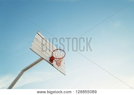 Basketball hoop on empty outdoor court .
