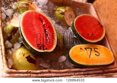 red and yellow water melon coconut for sale in ice water on the asian thai market