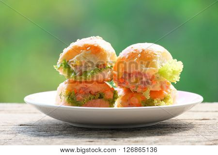 hambergers on the white plate on the wood floor