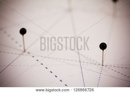 Black Pins In Paper Linked By Lines