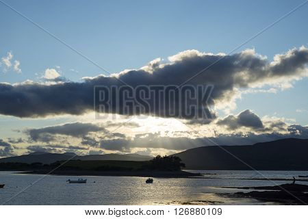 boats in a quiet bay with island near kenmare on the wild atlantic way ireland just before sunset