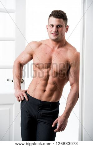 Athlete man standing in the doorway home interior