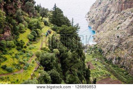 Group of tourists on a trail over a butterfly valley. Faralya Turkey.