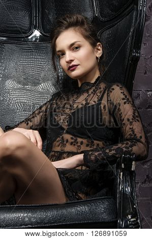 Girl Posing In A Big Black Leather Chair.