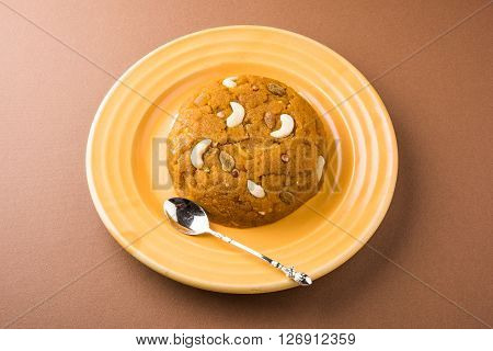 Moong Dal Halwa - a sweet dish from India, Indan Sweet Halwa made from Moong Dal, moong dal sweet sheera or shira cooked in pure ghee, served in a yellow ceramic plate