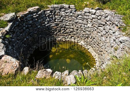 Draw well made of rocks, detail from panoramic view of Pester plateau landscape in southwest Serbia