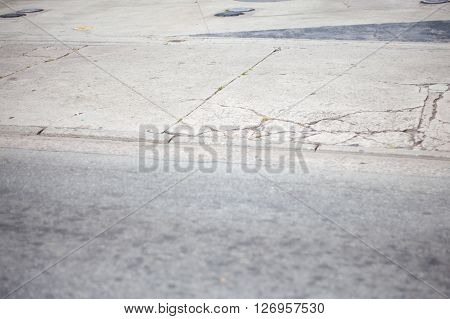 Broken sidewalk with metal caps and cracks
