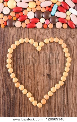 Heart shaped medical pills capsules or supplements for therapy concept of treatment and health care