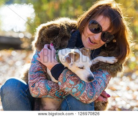 portrait of a woman with a dog on holiday in the autumn park  age of 40 years